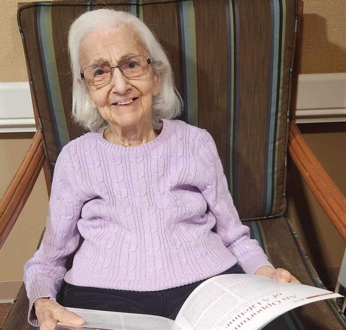 Person smiling with book in hand